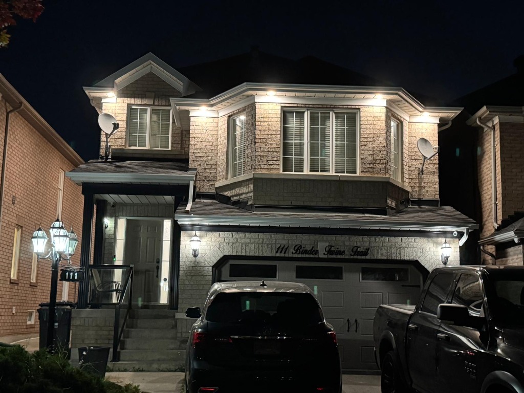Two-story house with illuminated exterior soffit lighting at night
